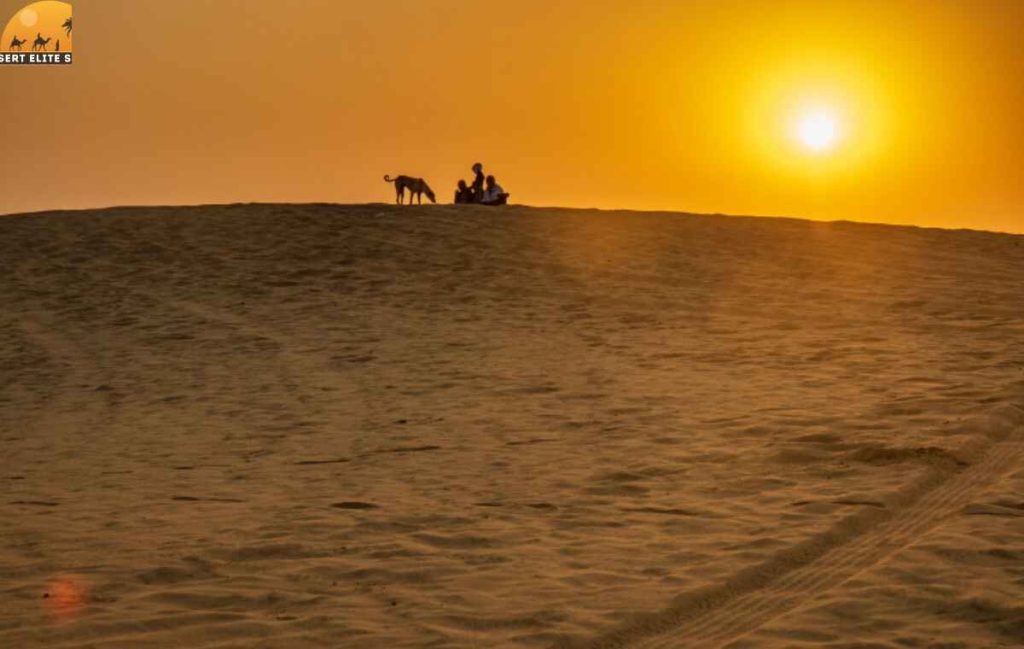 Traveler watching sunset over Sharjah desert dunes